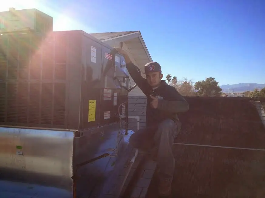 HVAC technician performing AC Tune-Up on a rooftop unit in Nixa